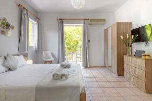a bedroom with a bed and a tv and a window at Faro Del Porto in Poros