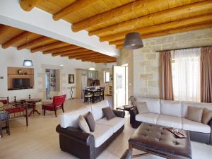un soggiorno con divano e tavolo di Villa Olivia with Pool Vrises Crete ad Alíkambos