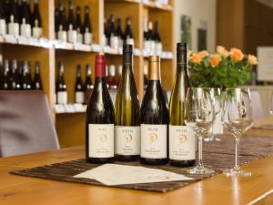 four bottles of wine sitting on a table with wine glasses at Gästehaus & Weingut PETH in Flörsheim-Dalsheim