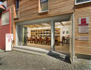 um restaurante com uma porta aberta com mesas e cadeiras em Gästehaus & Weingut PETH em Flörsheim-Dalsheim