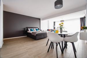 een woonkamer met een bed en een tafel en stoelen bij Lounge 8 Studios in Oradea