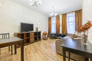 ein Wohnzimmer mit einem TV und einem Sofa in der Unterkunft STN Apartments by Moskovskiy Railway Station in Sankt Petersburg