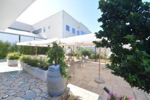 patio ze stołami i parasolami przed budynkiem w obiekcie Noemi B&B w mieście Modugno