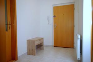 um corredor com um banco de madeira e uma porta em apartment golden Prague em Praga