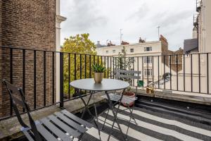 a balcony with a table and chairs on a building at Kula London - Victoria in London