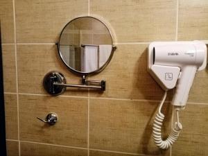a mirror and a hair dryer on a bathroom wall at Effect Boutique Villa Azzura - Adults Only SELF CHECK-IN in Nesebar