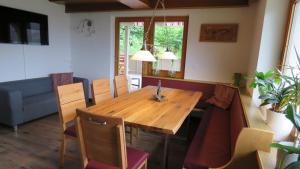 Un comedor con mesa y sillas de madera. en Braunhof Apartments, en Hainzenberg