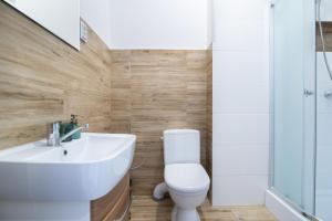 łazienka z białą umywalką i toaletą w obiekcie Pokoje Gościnne Wejherowo w Wejherowie