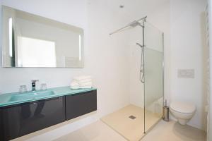 a bathroom with a sink and a toilet and a mirror at Villa Les Restanques in Bandol