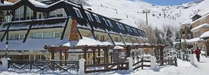 a building in the snow with a ski slope at Hotel Telecabina in Sierra Nevada