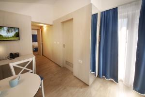 Olive Family Suites - Hotel & Resort Adria Ankaran的电视和/或娱乐中心