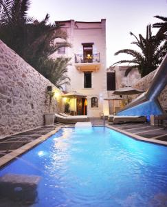 a swimming pool in front of a house at Antica Dimora Suites in Rethymno Town