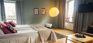 1 dormitorio con 1 cama y sala de estar en Maritim Hotell & Krog, en Simrishamn