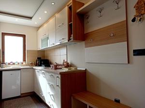une cuisine avec des placards blancs et une fenêtre dans l'établissement Modern Lux Apartment H8 at Milmari Resort, à Kopaonik