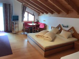 Schlafzimmer mit einem Bett, einem Tisch und einem TV in der Unterkunft Apart Bellezza in Samnaun