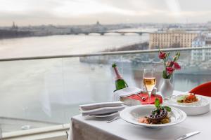 una mesa con dos platos de comida y una copa de vino en Saint-Petersburg Hotel, en San Petersburgo