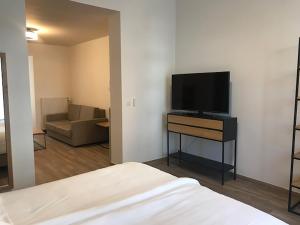 a room with a bed and a flat screen tv at Brussel House Basilic in Brussels