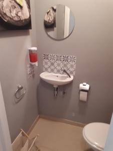 a bathroom with a sink and a mirror on the wall at Résidence Jersey (app. 201) in Koksijde