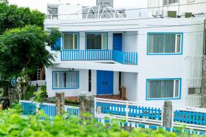 ein weißes Haus mit blauen Fenstern und einem Zaun in der Unterkunft You Yue B&B in Hualien