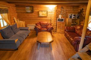 una sala de estar con muebles de cuero en una cabaña de madera en Soesauna Farmstay, en Vetla