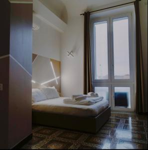 sypialnia z łóżkiem i dużym oknem w obiekcie Palazzo San Giorgio ( S ) w Genui