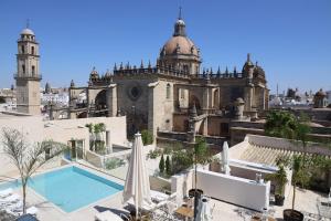 a large stone building with a swimming pool in front of it at Hotel Bodega Tio Pepe in Jerez de la Frontera