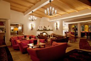 sala de estar con muebles de color rojo y chimenea en Hotel Plattenhof, en Lech am Arlberg