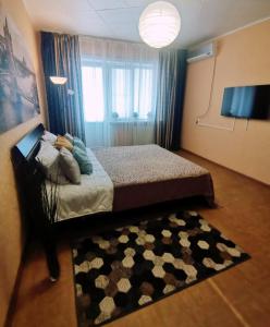 ヴォルゴドンスクにあるApartment on Stroiteley 7aのベッドルーム1室(ベッド1台、ラグ、窓付)