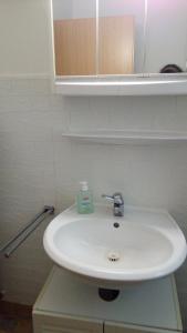 - białą umywalkę w łazience z lustrem w obiekcie Zimmervermietung Pargen w mieście Daun