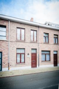 - un bâtiment en briques avec des portes rouges dans une rue dans l'établissement Holiday Home 't Regulierenhuisje, à Tongres