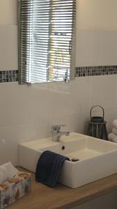 a bathroom with a white sink and a mirror at Le Clos De La Roche in Goven