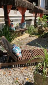 a wooden bench with pillows sitting in a garden at Pousada D'Pillel in Abraão