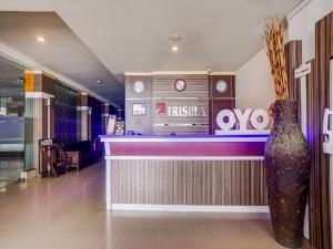 um restaurante com um bar com um vaso no balcão em Super OYO 3936 Hotel Trisula Makassar em Makassar