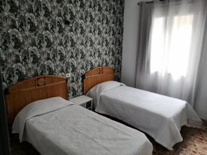 A bed or beds in a room at Alcaravaneras Hostel