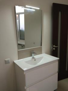 a bathroom with a white sink and a mirror at Modern apartment in Lviv