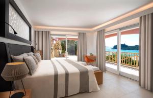 een slaapkamer met een bed en uitzicht op de oceaan bij Villa Mannus - Splendida villa vista mare con piscina in Villasimius +22 foto's