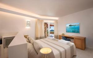een hotelkamer met een bed en een televisie bij Villa Mannus - Splendida villa vista mare con piscina in Villasimius