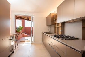a kitchen with white cabinets and a stove top oven at Villa Mannus - Splendida villa vista mare con piscina in Villasimius