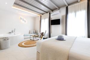 Habitación blanca con cama y baño. en Kandiani Bleu Ciel en Naousa