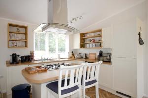 a kitchen with white cabinets and a island with a stove at Hollicarrs - Woodland Lodge in York
