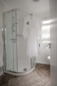 um roupão pendurado num chuveiro na casa de banho em Hollicarrs - Woodland Lodge em York