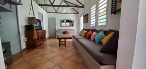 - un salon avec un canapé et des oreillers colorés dans l'établissement La Maison Dakoté, à Sainte-Clotilde
