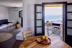 a dining room with a table and a view of the ocean at Acron Villas Paros in Kolympithres