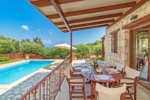 un patio avec une table et des chaises à côté d'une piscine dans l'établissement Elegance Villas, à Argassi