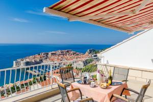 balcón con mesa, sillas y vistas al océano en Apartments Cicko en Dubrovnik
