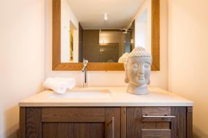 a bathroom with a sink with a statue of a head at Lütt Hüs in Wenningstedt