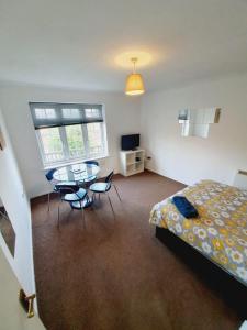 a bedroom with a bed and a table and chairs at 2 Bedroom Rayleigh Apartment in Rayleigh