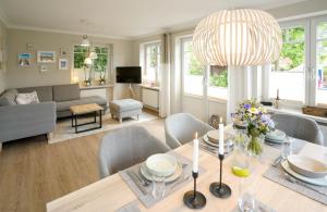ein Wohnzimmer mit einem Esstisch und einem Sofa in der Unterkunft Ferienhaus Meerweh Sylt in Westerland