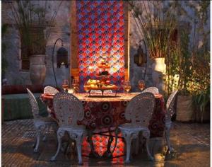 una mesa y sillas en una habitación con una pared roja en Riad Idrissy, en Fez