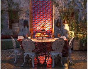a table and chairs in a room with a red wall at Riad Idrissy in Fès +27 photos